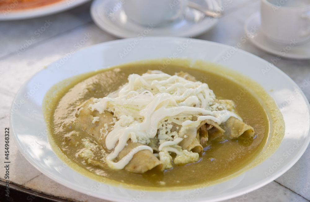 Green Enchiladas - traditional mexican food with tomato sauce and cheese in Mexico