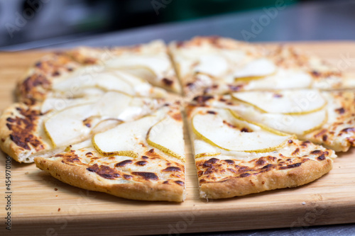 pizza with pear on a wooden board