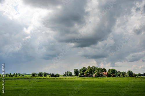 Zwolle, The Netherlands, August 10, 2021: Dramatic skies and spectacular lighting conditions over the polder landscape along the IJssel river