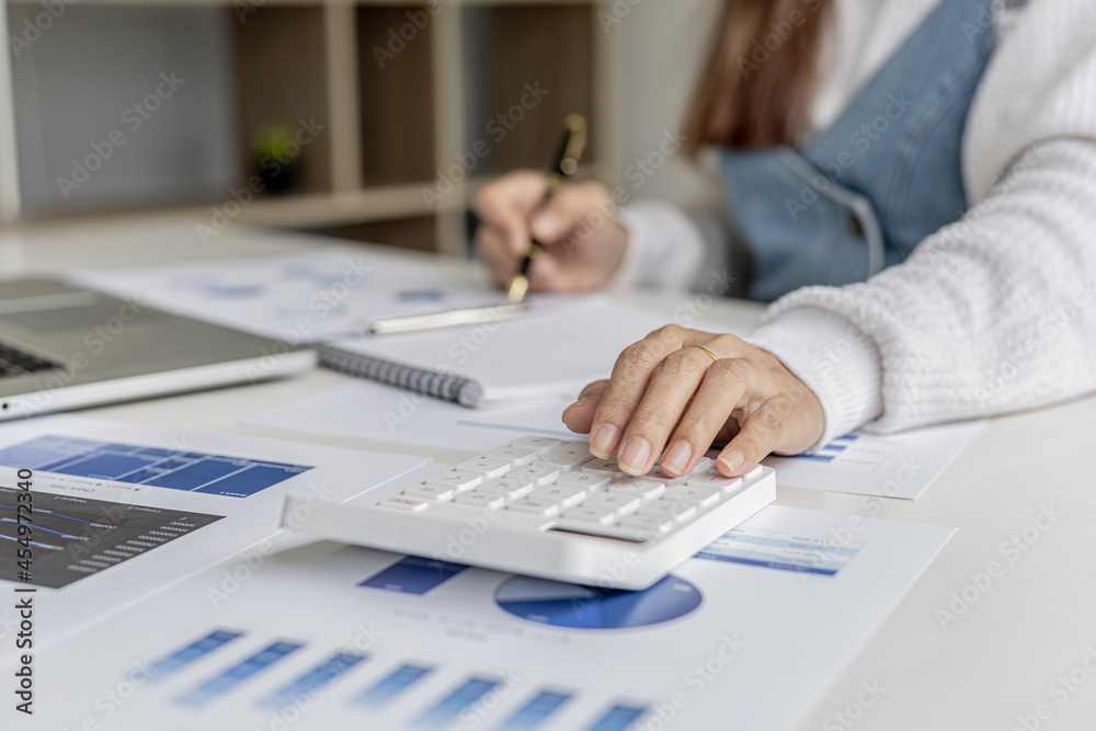 Woman holding a pen pointing to documents on a desk, she is a financial scholar, she is checking company financial documents for accuracy before presenting them to executives. Financial audit concept. Woman holding a pen pointing to documents on a desk, she is a financial scholar, she is checking company financial documents for accuracy before presenting them to executives. Financial audit concept.