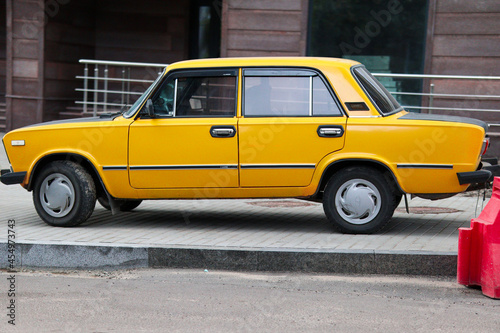 Bright yellow soviet car and cloudy day