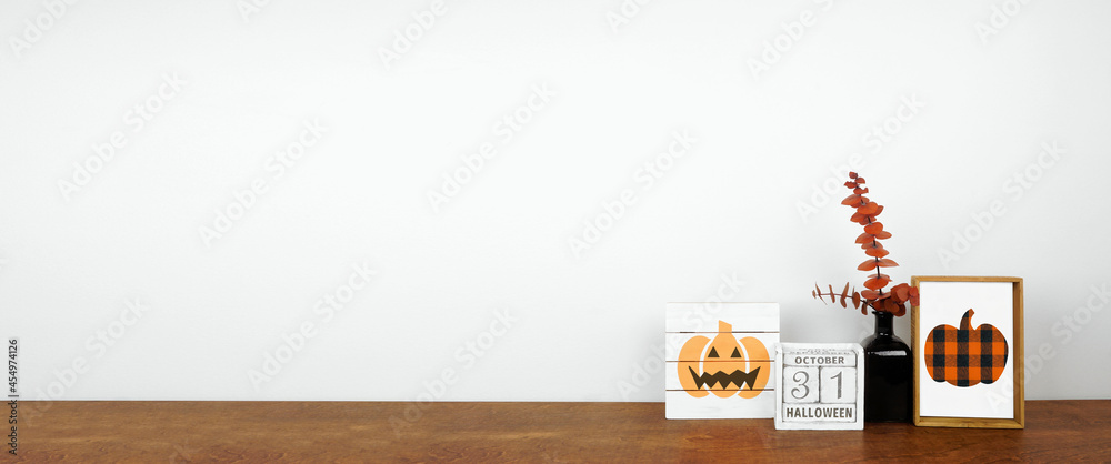 Halloween decor on a wood shelf. Shabby chic wood signs, calendar and orange branches against a white wall banner. Copy space. - obrazy, fototapety, plakaty 