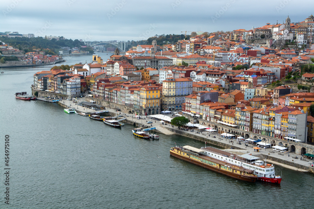 Porto, Portugal, October 31,2020. View on colorful old houses on hill in old part of city and embankment of Douro river in rainy day