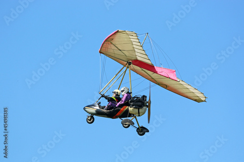 	
Ultralight airplane flying in a blue sky	 photo