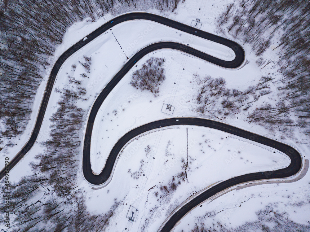 Winter aerial top view of the road to Olympic mountain village Rosa Plato. Beautiful winter landscape from drone.