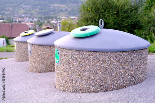 row of metal waste containers for separate sorting at public urban waste collection site in courtyard of apartment building in France, concept of cleanliness, recycling and disposal of household waste