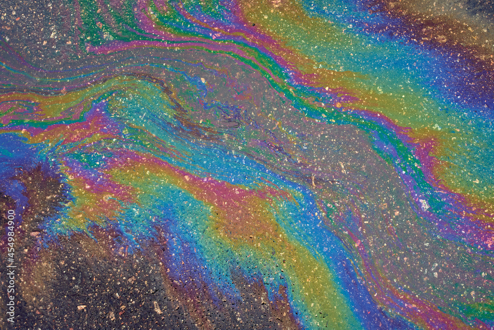 Abstract background from motor oil, gas or petrol spilled on asphalt