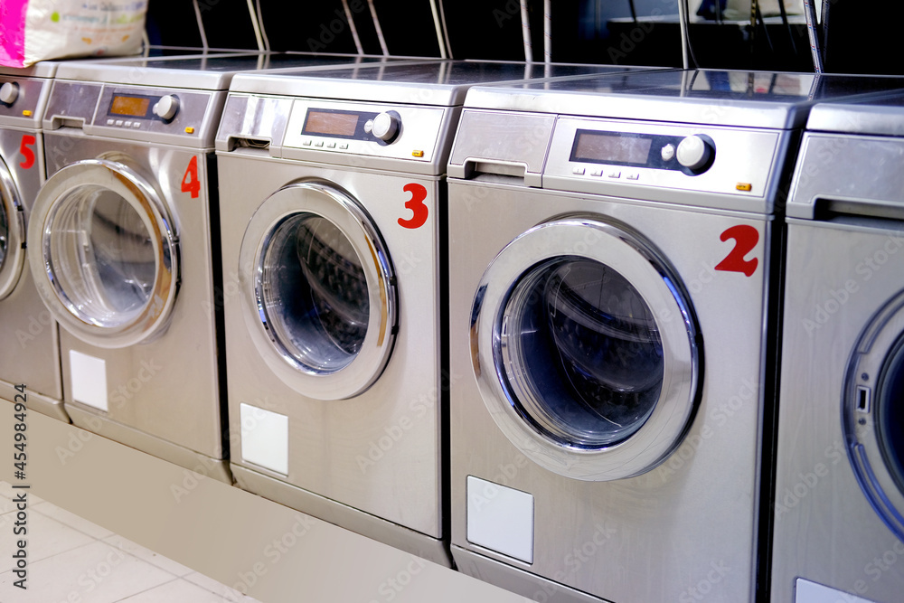 row of washing machines in public city self-service laundromat, clean linen concept, washing clothes, bachelor life row of washing machines in public city self-service laundromat, clean linen concept, washing clothes, bachelor life