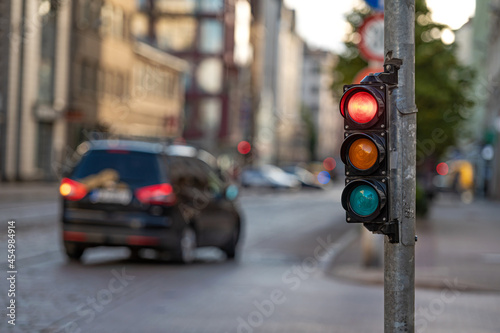 view of city traffic with traffic lights, in the foreground a traffic light with a red light