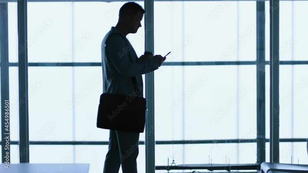 silhouette businessman using smartphone texting browsing messages on mobile phone sending email communication networking online waiting in office 4k silhouette businessman using smartphone texting browsing messages on mobile phone sending email communication networking online waiting in office 4k