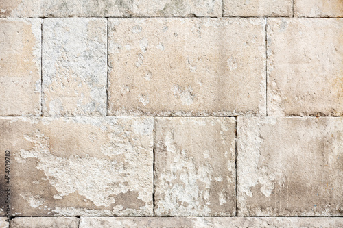 muro de piedra con textura de muralla antigua medieval desgastada, con colores cálidos close-up