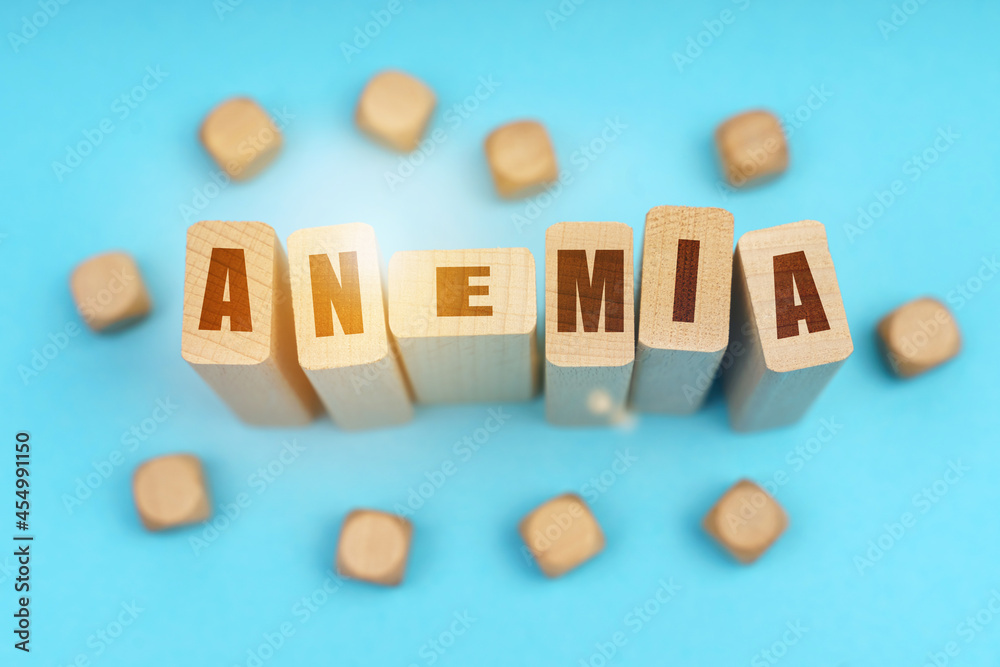 On a blue background, wooden cubes and Jenga with the inscription - ANEMIA On a blue background, wooden cubes and Jenga with the inscription - ANEMIA