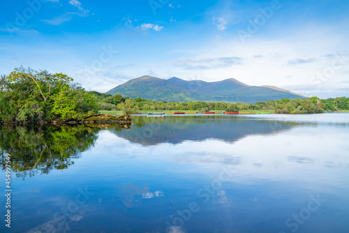 Scenic view across Lake Ross to boats on other-side and distant mountains with light and shadow from sun and clouds, Killarney National Park © Brian Scantlebury