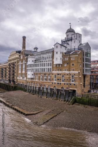 Edificio de una vieja factoría a orillas del río Támesis en el centro urbano de la ciudad de Londres photo