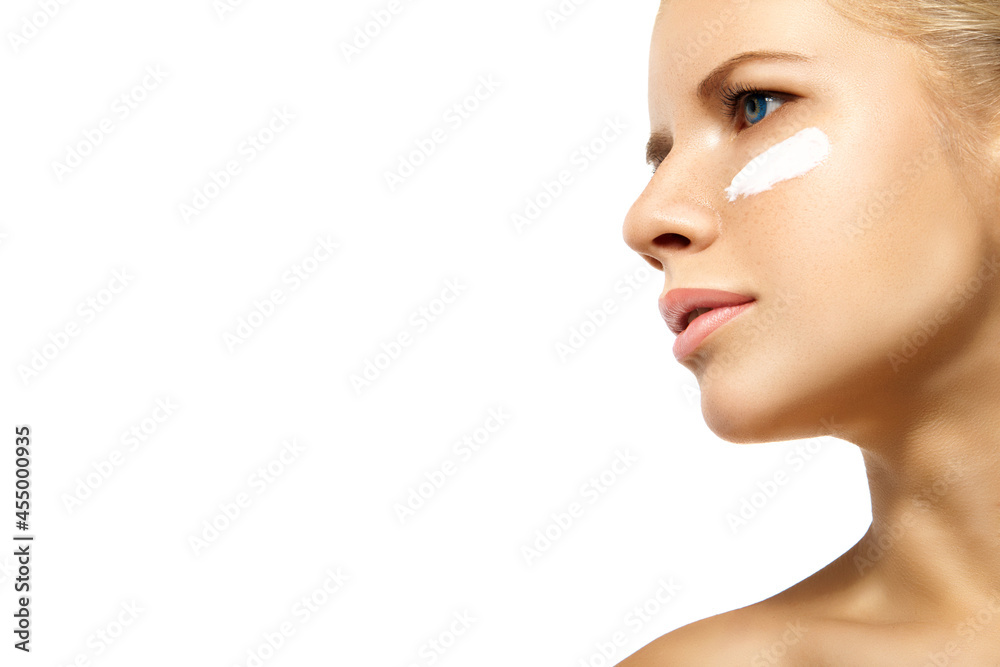 Woman applying moisturizer cream on face isolated Woman applying moisturizer cream on face isolated