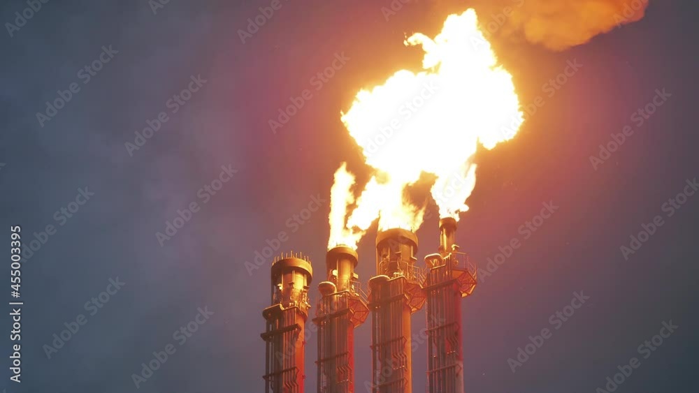 Flare stacks of the oil refinery releasing fire