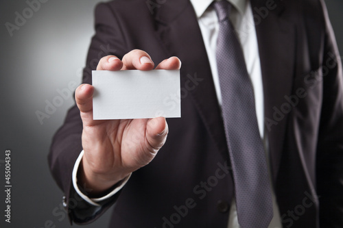 business man show card on dark grey