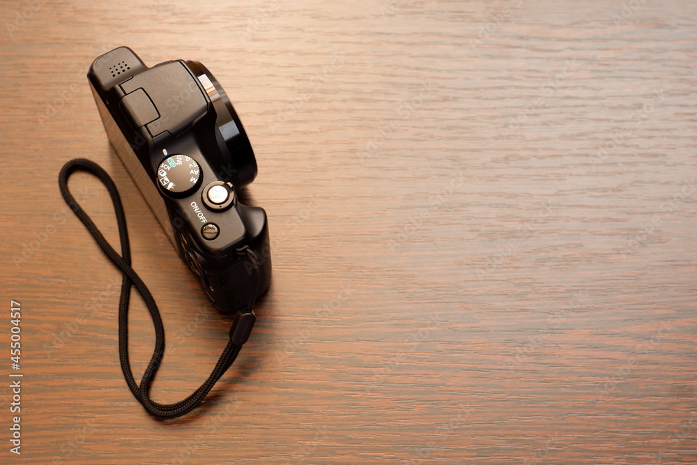 Compact digital camera on a wooden surface Compact digital camera on a wooden surface