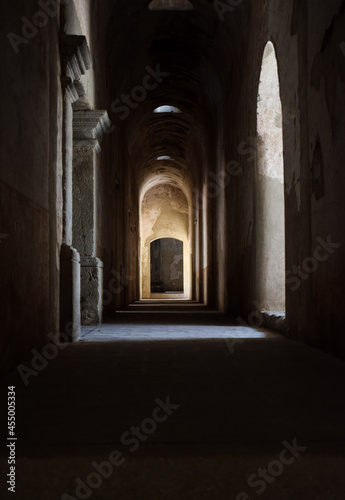 Pasillo obscuro, al fondo una luz que entra durante el dia. Ruinas de Santa Clara en Antigua Guatemala.