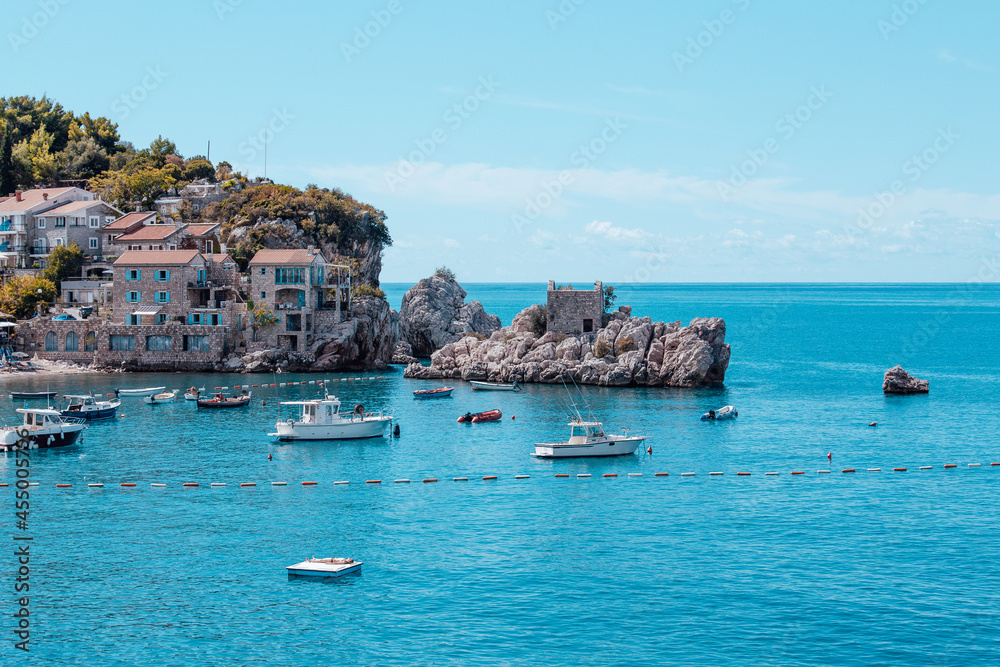 A picturesque sea bay among the mountains and rocks on the Adriatic sea coast. Mediterranean seascape with houses tiled roofs and boats on bay