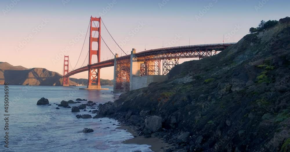 Aerial: Golden Gate Bridge and waves crashing on Marshall Beach at sunrise. San Francisco, USA Aerial: Golden Gate Bridge and waves crashing on Marshall Beach at sunrise. San Francisco, USA