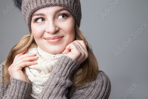 Beautiful blond girl wears winter scarf and hat photo