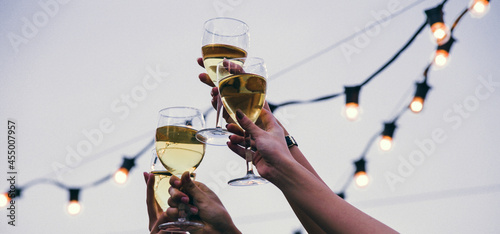 Celebration in hand holding champagne glasses and saying cheers It represents happiness, fun, success, and unity. photo