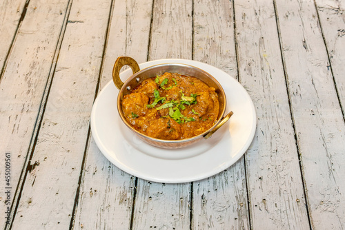 Mild dry curry with lamb stew juice in pure Hindu bhuma style in traditional metal bowl photo