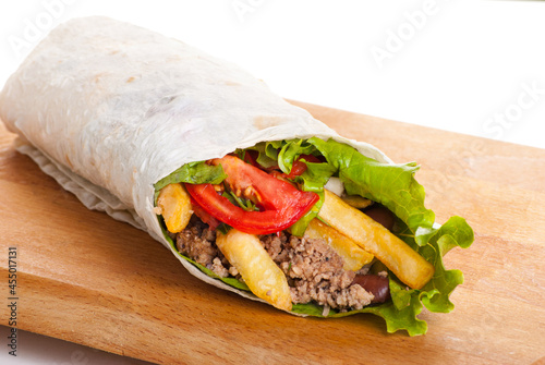 beef burrito with peppers, fried potato and tomato