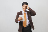Disappointed Asian businessman in suit and tie got bad news from smart phone