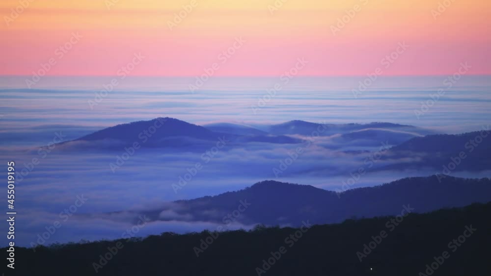 High angle aerial view above inversion clouds at sunrise morning in Wintergreen Resort, Virginia ski town with colorful sky, autumn fall trees in Blue Ridge mountains High angle aerial view above inversion clouds at sunrise morning in Wintergreen Resort, Virginia ski town with colorful sky, autumn fall trees in Blue Ridge mountains