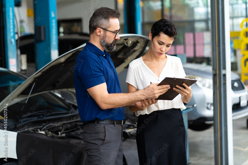 Car insurance concept. Insurance Agent examine Damaged Car with woman customer write information on Report Claim Form. Car insurance concept. Insurance Agent examine Damaged Car with woman customer write information on Report Claim Form.