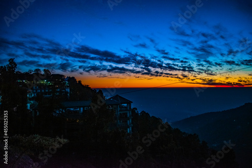 Sunset view from mountains in Himachal Pradesh with a view of houses on hills