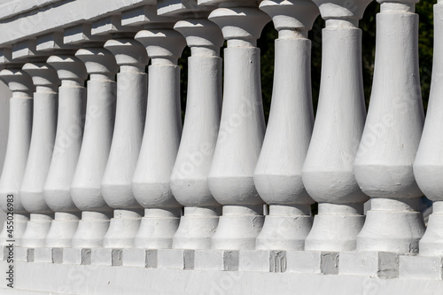 Details of the architecture of the city - a white fence, symmetry of the fence supports of a streamlined classical form