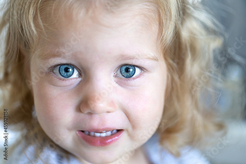 Portrait of a little tear-stained girl with big blue eyes.