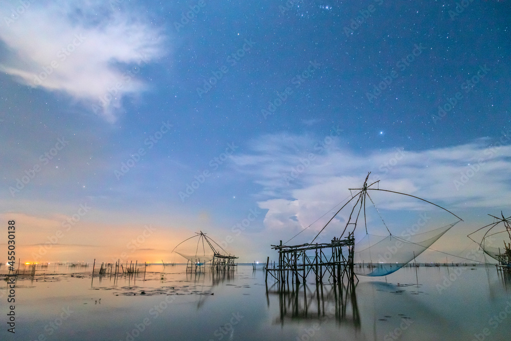 The silhouette of the dipped net against the sky background, stars, sunrise. The way of life of fishermen at Pak Pra Phatthalung in Thailand The silhouette of the dipped net against the sky background, stars, sunrise. The way of life of fishermen at Pak Pra Phatthalung in Thailand