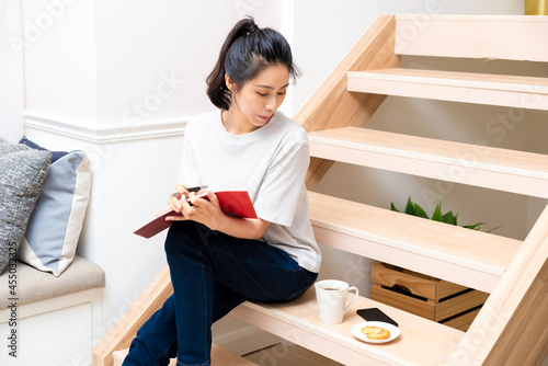 Young hipster woman writing journal on small notebook