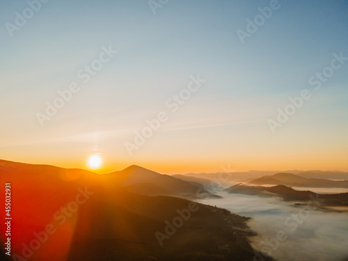 aerial view of sunrise above mountain range © phpetrunina14
