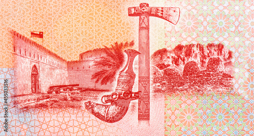 Flag flying over Khasab Castle; Omani khanjar (dagger) and jirz (axe); Wadi Al-Ayn tombs; crossed swords and khanjar. Portrait from Oman 1 Rials 2020,2021 Banknotes. photo
