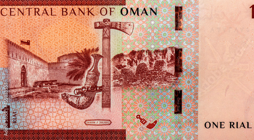 Flag flying over Khasab Castle; Omani khanjar (dagger) and jirz (axe); Wadi Al-Ayn tombs; crossed swords and khanjar. Portrait from Oman 1 Rials 2020,2021 Banknotes. photo