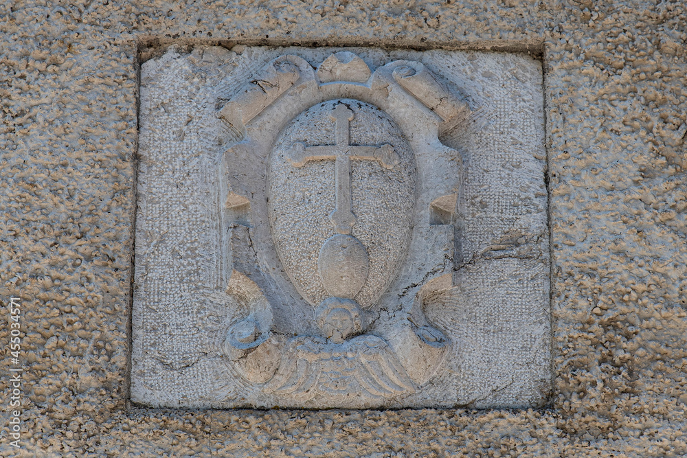 Symbol of the Chartreuse cross on a stone
