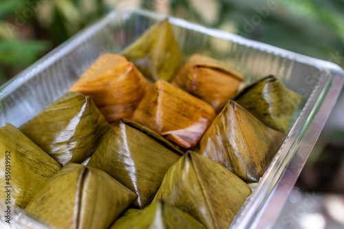 Stuffed dough pyramid thai dessert called Ka-Nhom-Tian. Desserts wrapped in banana leaves. Ka Nhom Tian is popular in auspicious ceremony, especially in Chinese New Year in Thailand.  photo