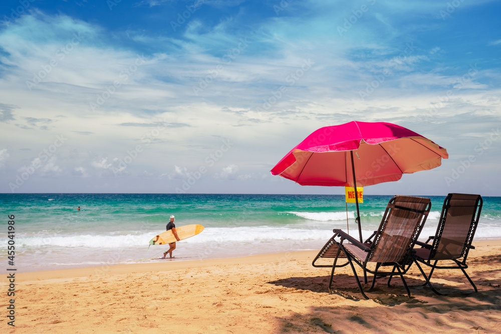 beach chairs and umbrella on the beach.Surfboard on tropical beach in summer beach sunny day.