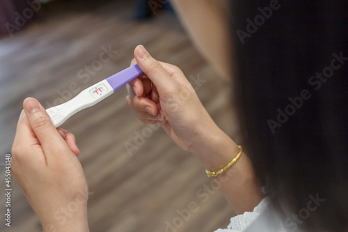Hand holding the pregnancy test is showing a positive result.