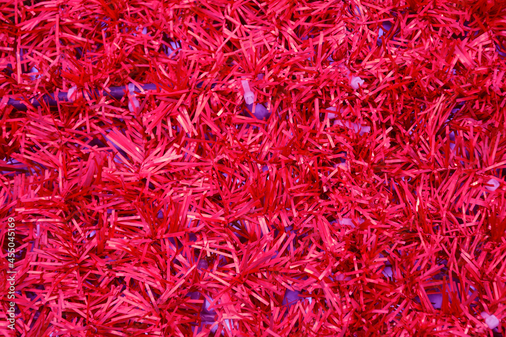 Vibrant red background of glowing tinsel