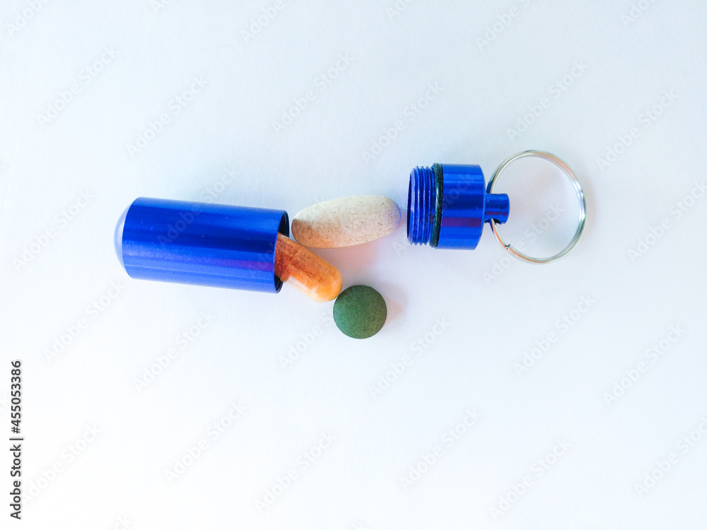 blue pill box with pills on white background blue pill box with pills on white background