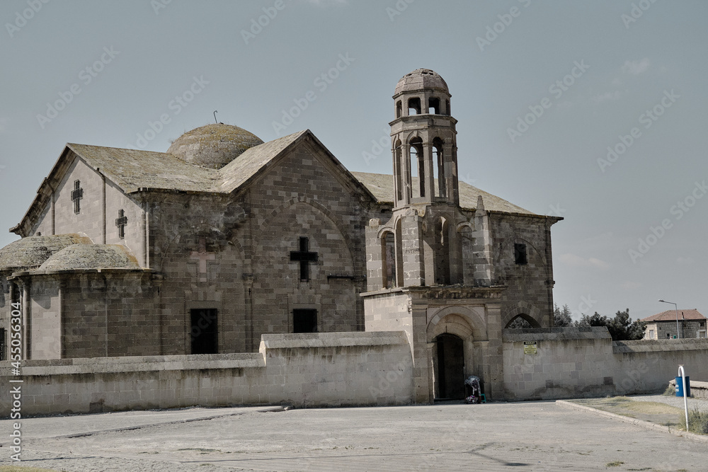 A watchman and beggar woman in front of St. Theodoros Trion Church (Uzumlu Kilise) established in 19th century by Ottoman Empire with its seljuk magnificent architecture. 23.07.2021. Derinkuyu. Turkey
