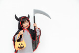 Children girl wearing mysterious Halloween dress holding a scary pumpkin and sickle.