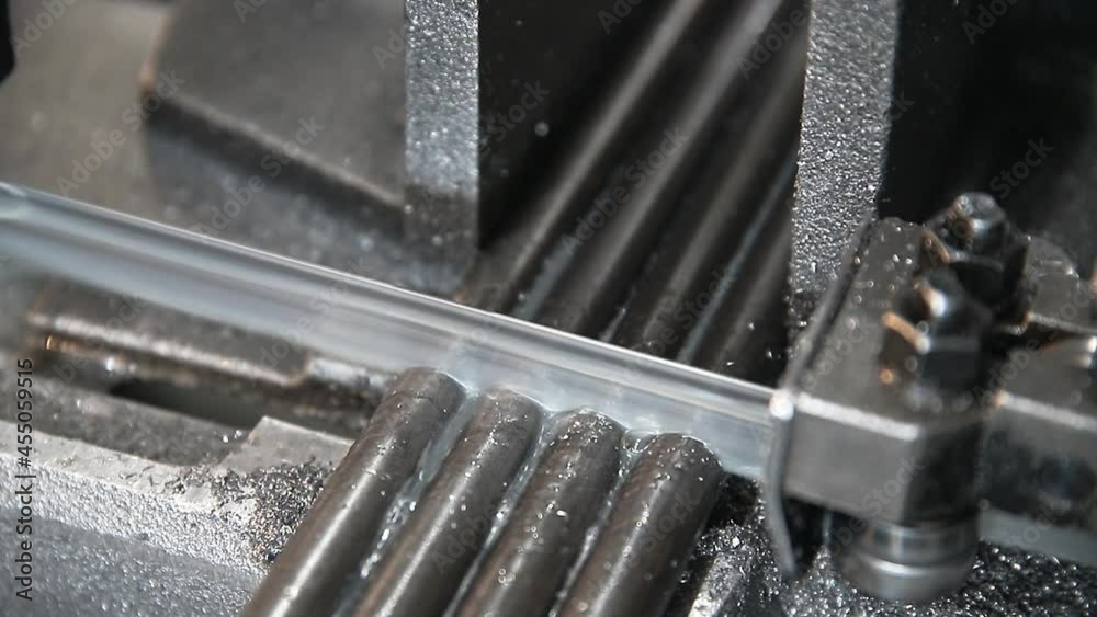 automatic saw with coolant cuts parts, close-up