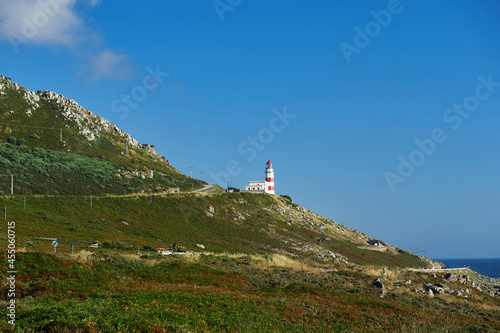 the lighthouse of cabo silleiro in the middle of a mountain slope on the coast photo
